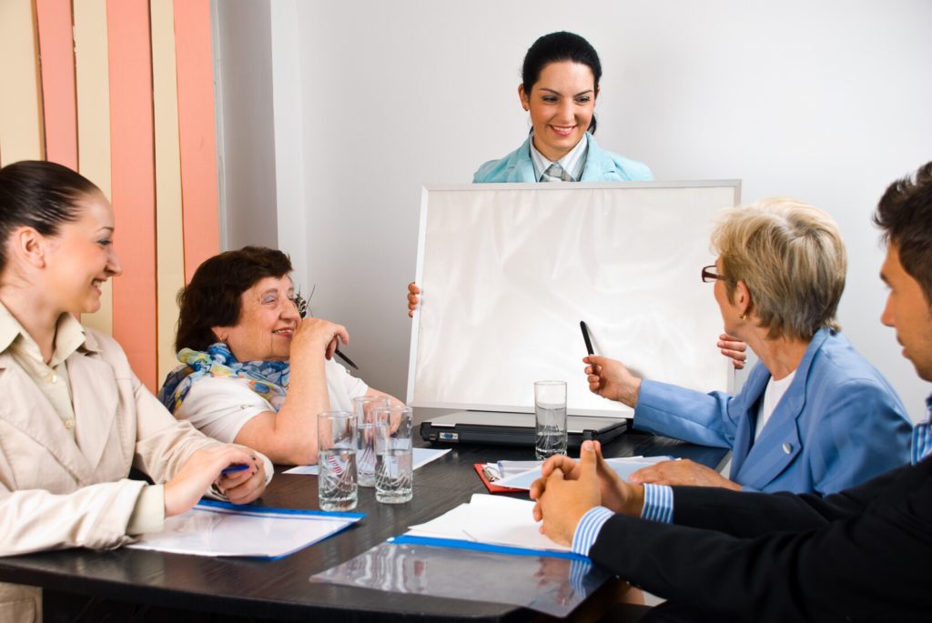 Five people of various ages meeting around a table. One woman is holding a chart and another is gesturing toward the chart.
<!-- HTML Credit Code for Can Stock Photo -->
<a href=