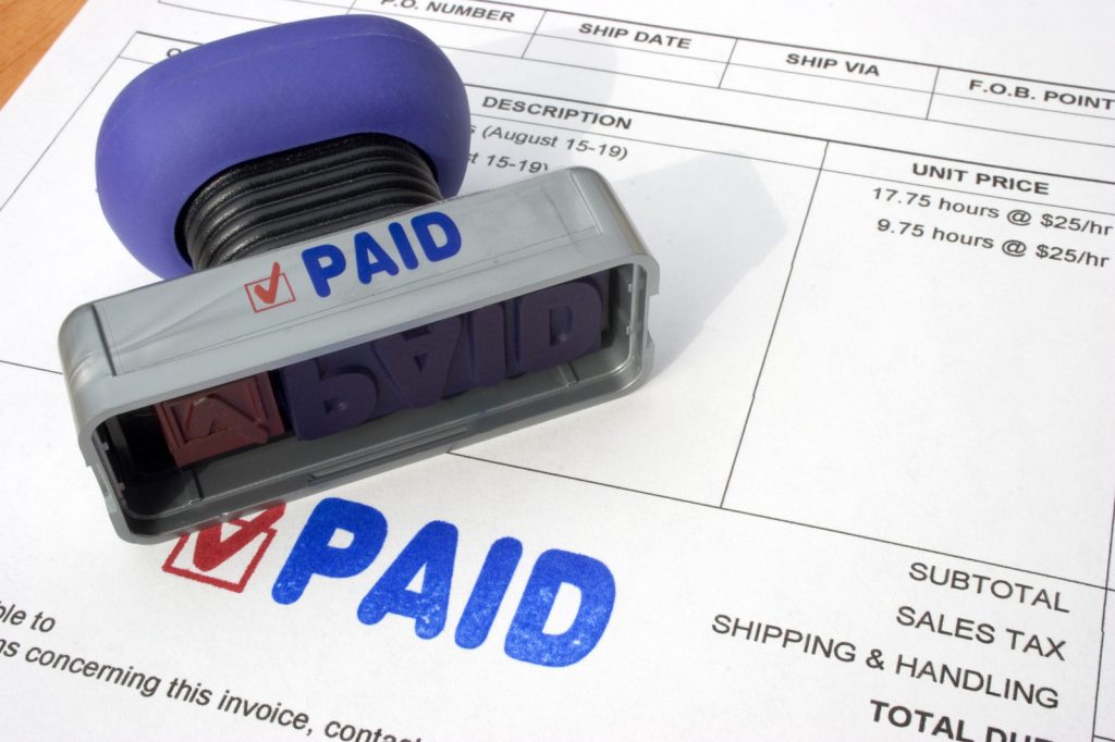 Photo of a bill with a stamp and marked paid.